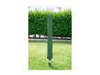 Green rotary clothesline cover in a garden with a hedge and house in the background.