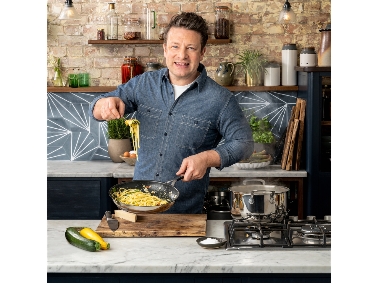 Jamie Oliver gătește paste într-o tigaie Tefal, cu o oală alături.