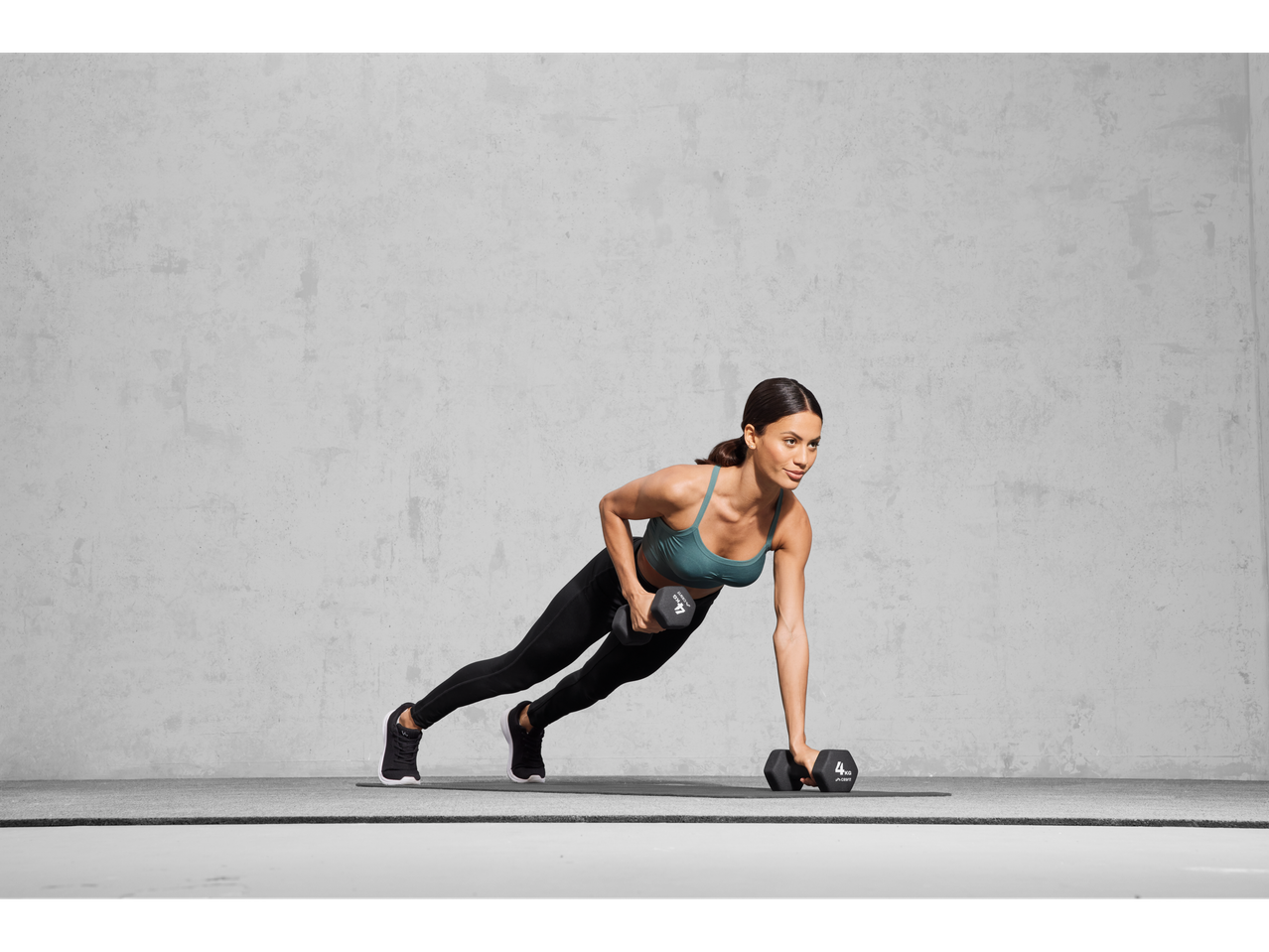 Woman doing a plank with 4kg dumbbells.