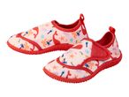 Pair of pink children's water shoes with a red trim and a playful whale and palm tree pattern.