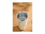 Cream-colored insulated tumbler on a wooden surface.