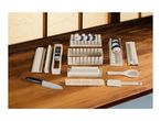 Sushi making kit with various molds, a knife, bamboo mat, and utensils on a wooden surface.