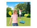 Two children playing an outdoor swingball game with rackets in a sunny garden.