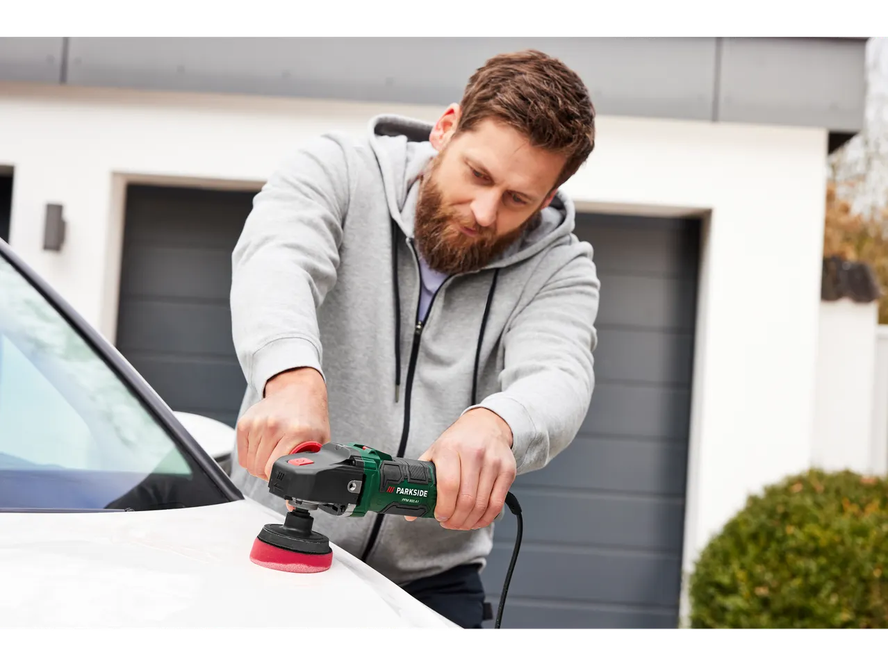 Man polishing a car with a Parkside polisher.