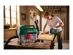 A wet and dry vacuum cleaner and a jigsaw being used by a person in a workshop.