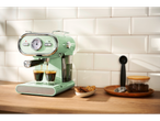 SilverCrest aparat za espresso u boji mente s dvije šalice kave i kolačićima.