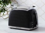 Black toaster with a geometric pattern and a warming rack on a marble countertop.