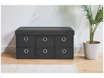 Un banc de rangement noir avec six tiroirs et un coussin rembourré, à côté d'une plante en pot.
