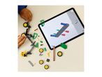 Overhead view of a child building a toy tractor with an instruction tablet.