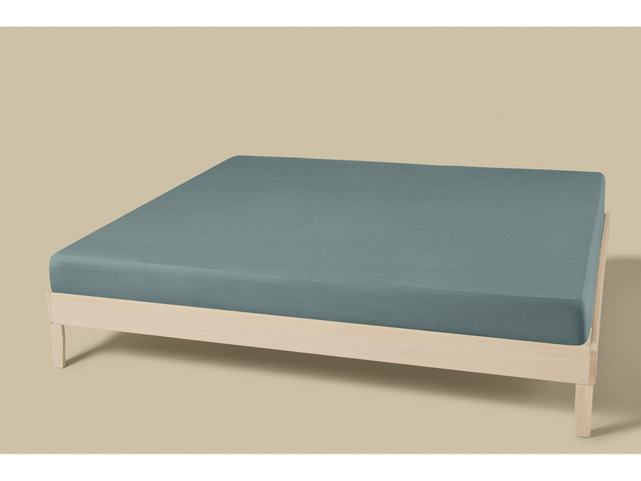 Livarno Sateen Fitted Sheet in teal on a light wooden bed frame.
