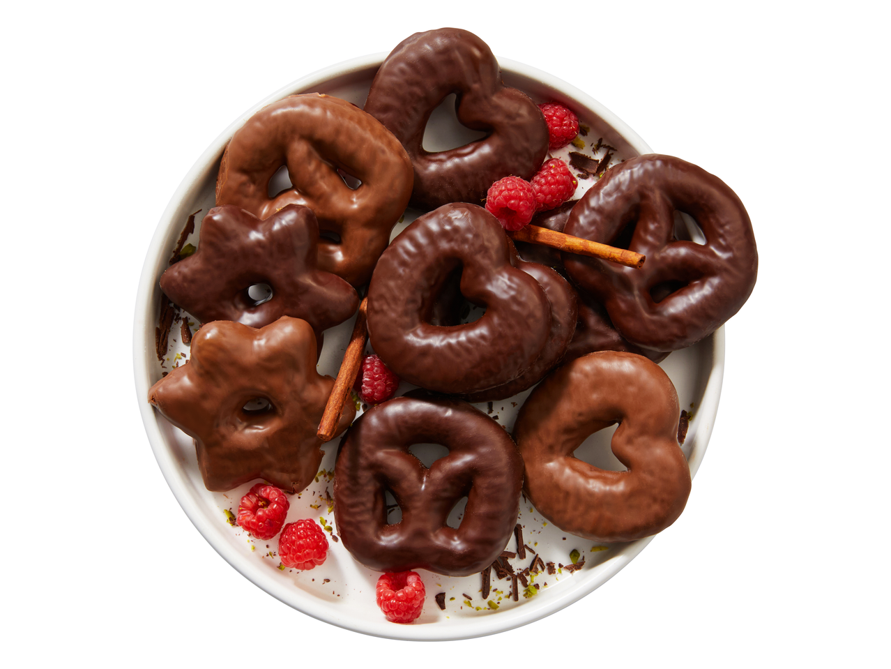 Favorina Chocolate Gingerbread Shapes with raspberries and cinnamon sticks on a white plate.