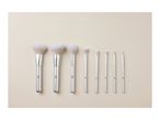 A set of three larger makeup brushes and several smaller detail brushes.