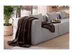 Cozy brown faux fur blanket draped over a modern grey sofa with a tea tray.