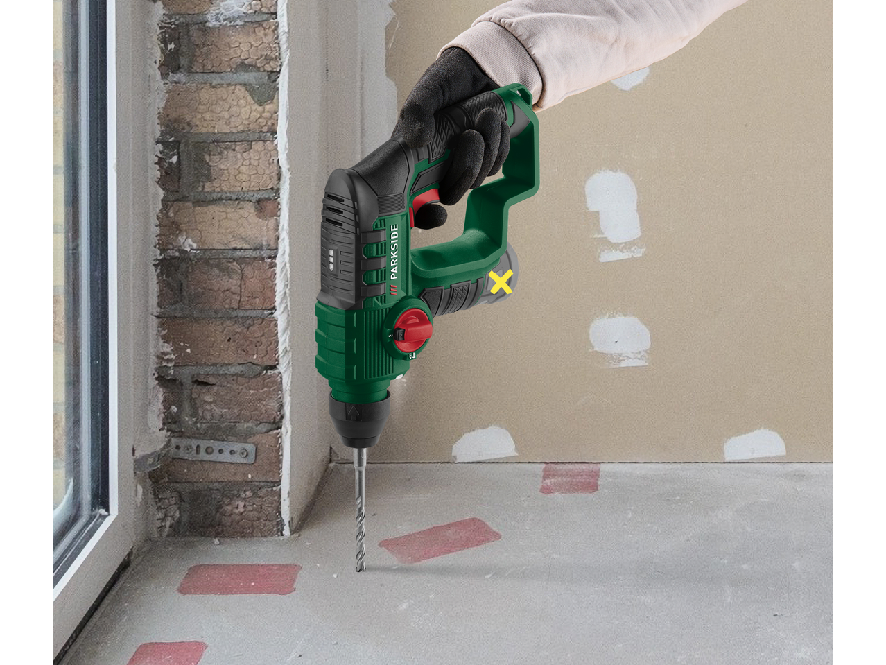 Ciocan rotopercutor PARKSIDE verde, forând într-o podea de ciment.