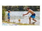Father and son playing with a ball in the lake, wearing swim shorts and a rash guard.