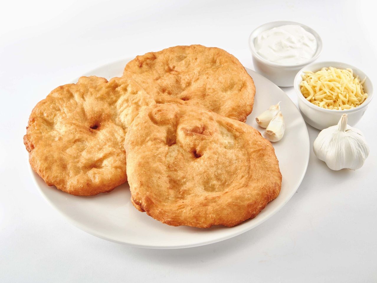 Három pogácsa, reszelt sajt, joghurt és fokhagyma.