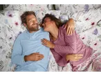 Couple in pajamas and floral bedding.