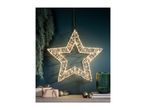 Illuminated star decoration hanging on a dark wall, with gifts and ornaments on a shelf.