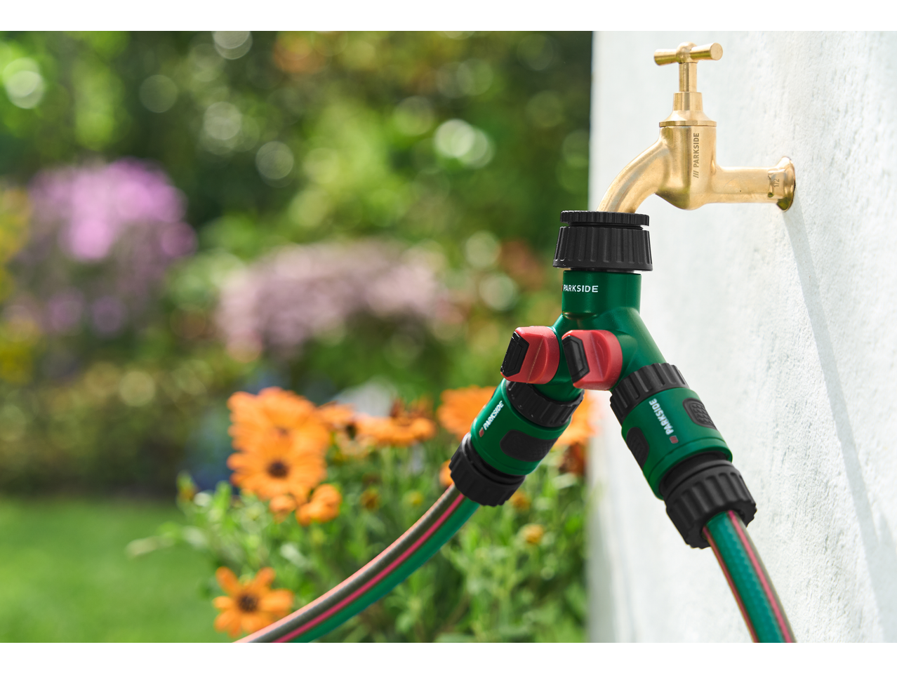 Conjunto de ligação de rega PARKSIDE com mangueira verde e torneira de latão no jardim.