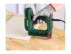 Electric stapler being used to attach canvas to a wooden frame on a workbench.