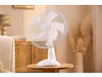 Ventoinha de mesa Tronic num quarto luminoso com móveis de madeira e plantas.