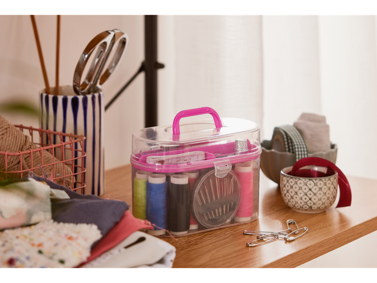 Thread, needles, and sewing supplies in a clear case.