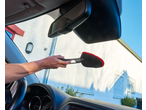 Hand cleaning car windshield with a red microfiber cleaning tool from the ULTIMATE SPEED® Car Cleaning Assortment.