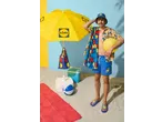 Man in Lidl short sleeve shirt, swim shorts, and bucket hat, with Lidl beach gear.