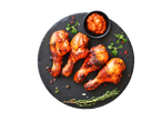 Neli grillitud kanakoiba mustal taldrikul koos kastme ja ürtidega.