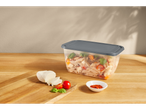 Pasta salad in a plastic container with lid, mozzarella, and spices.