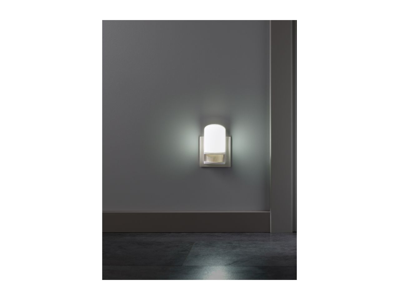 Night light with motion sensor illuminating a dark hallway.