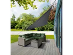 Rattan furniture and triangular shade sail on a patio.