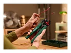 Hands using an automatic wire stripper on electrical wires, with a tool case nearby.