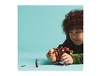 A child playing with a red and gold robot toy and a small silver robot figure.