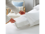 White sheets and pillowcases on a bed.