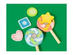 Colorful wooden toy lollipops and felt shapes on a green background.