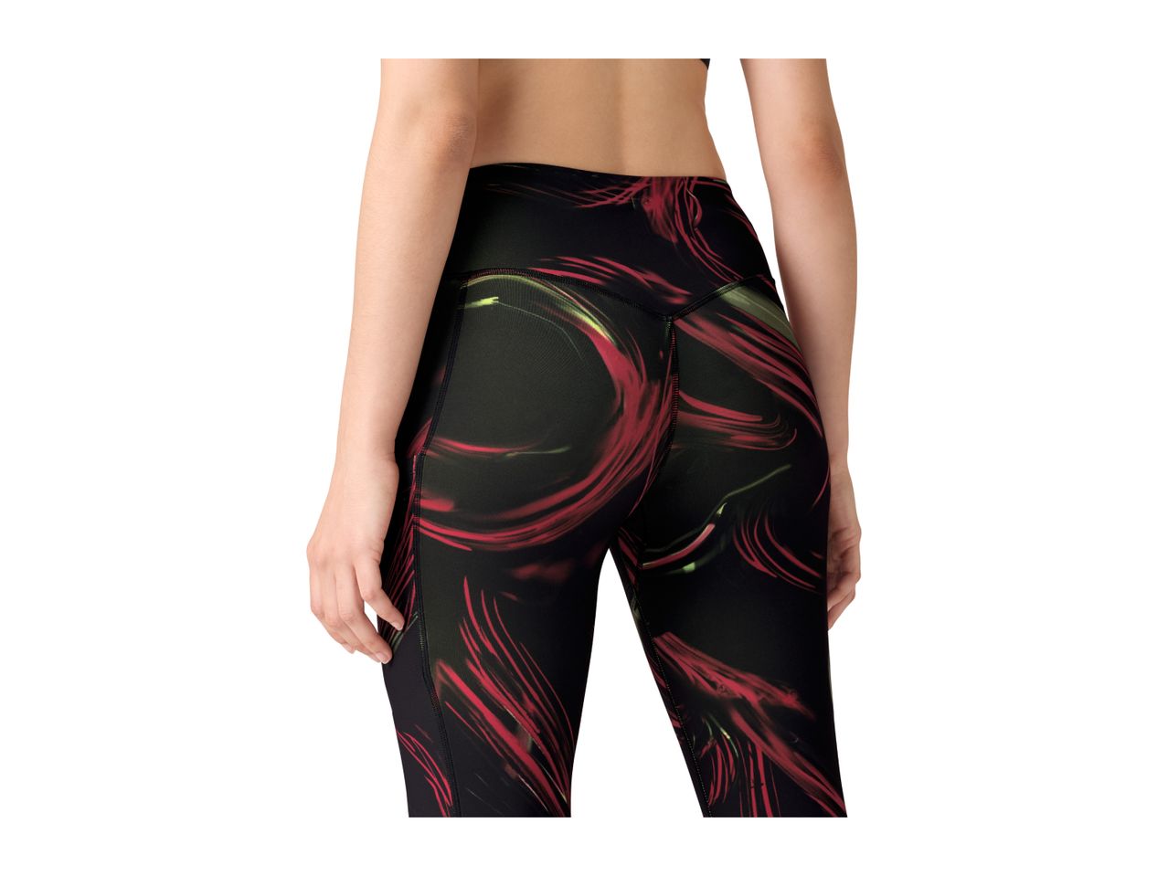 Woman from behind wearing black leggings with red and green abstract patterns.