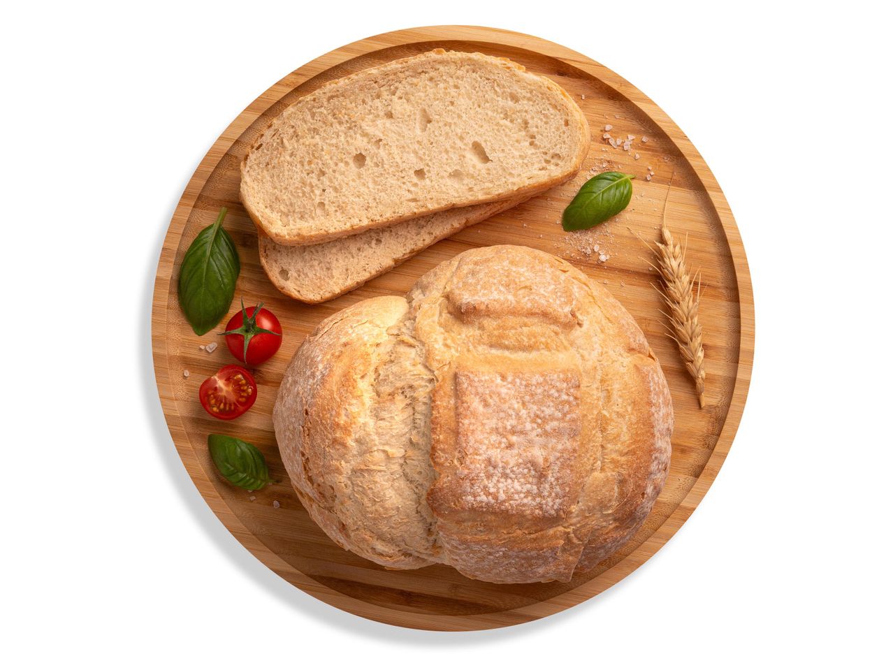 Friss kenyér, szeletelt kenyér, paradicsom, bazsalikom és búzakalász egy fa tálcán.