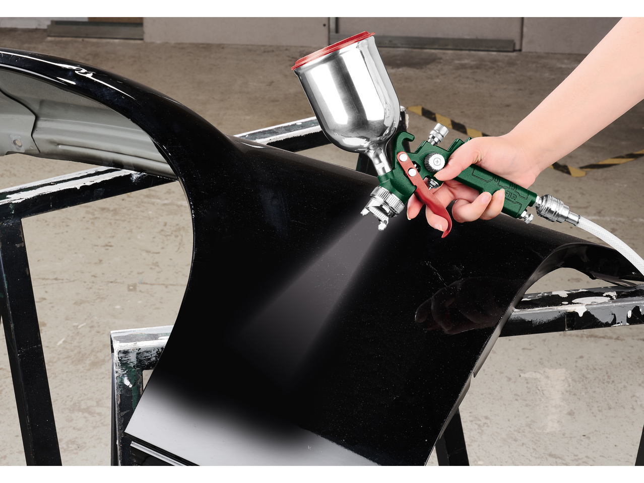 Ruka prska crni auto-deo Parkside pištoljem za farbanje