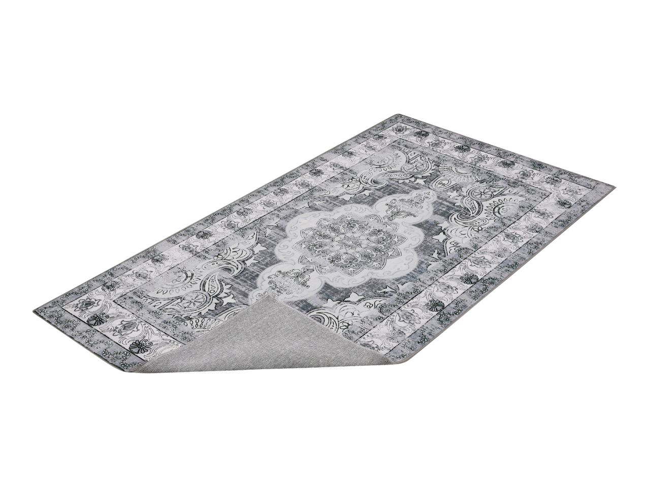 Grey patterned rug with a non-slip backing shown folded over at one corner