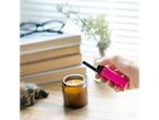 BIC lighter and candle on a wooden table.