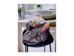 Person putting a food container with potato wedges into a grey handbag.