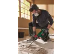 A man uses a Parkside 1650W demolition hammer to remove floor tiles.