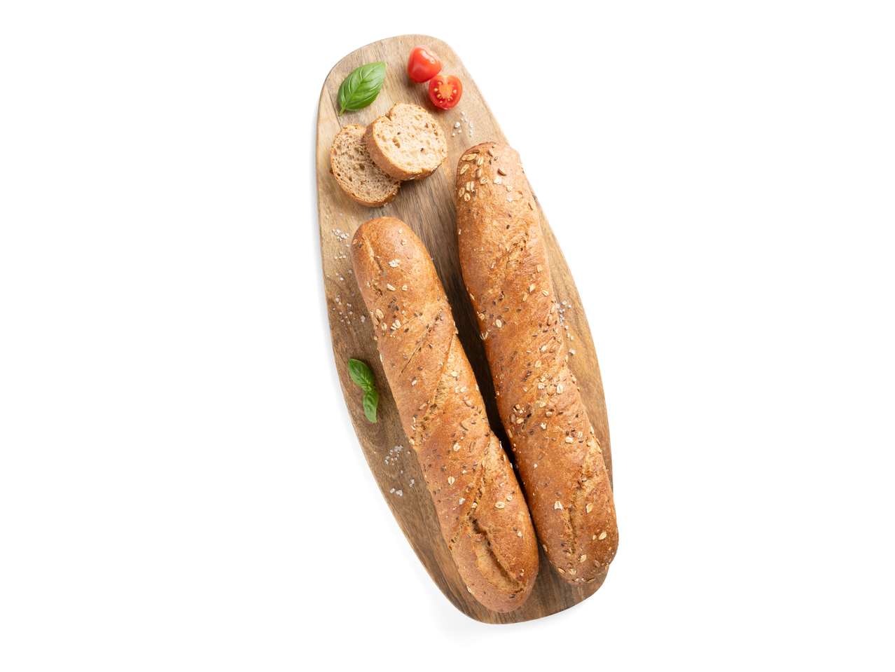Teljes kiőrlésű sokmagvas bagettek vágódeszkán paradicsommal és bazsalikommal