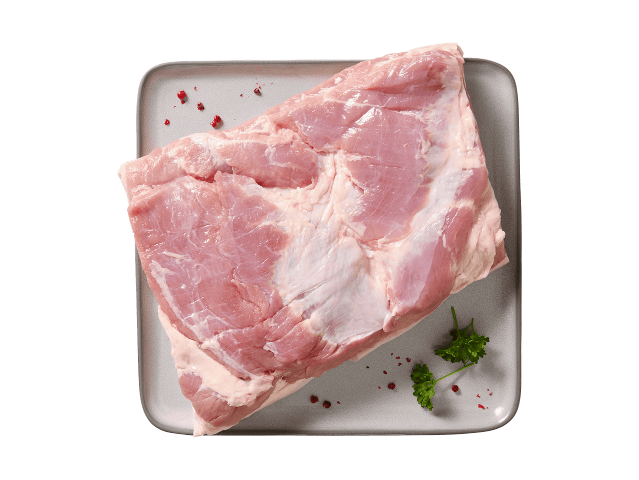 Frisches Schweinefleisch auf einer grauen Platte mit Petersilie und rosa Pfeffer.