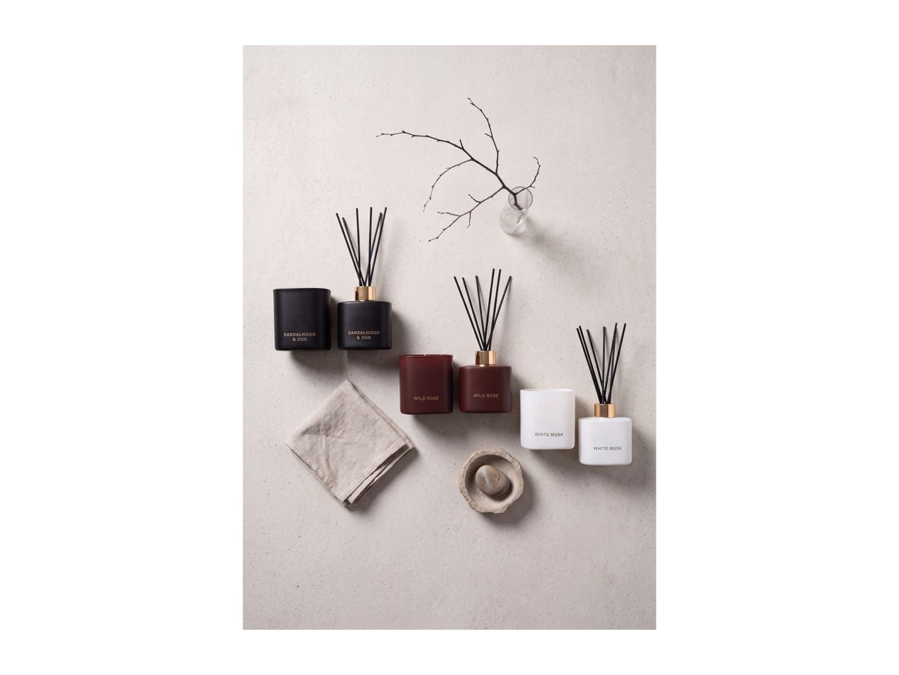 Scented candles and reed diffusers in Sandalwood & Oud, Wild Rose, and White Musk.