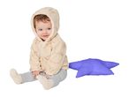 A baby in a beige hooded fleece jumpsuit with teddy bear patterns, sitting next to a purple star pillow.