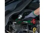 Hand using a cordless ratchet wrench to work on a car engine.