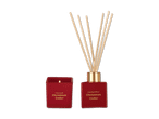Rote Weihnachts-Duftkerze und Reed-Diffusor mit der Aufschrift „Christmas Cedar“.