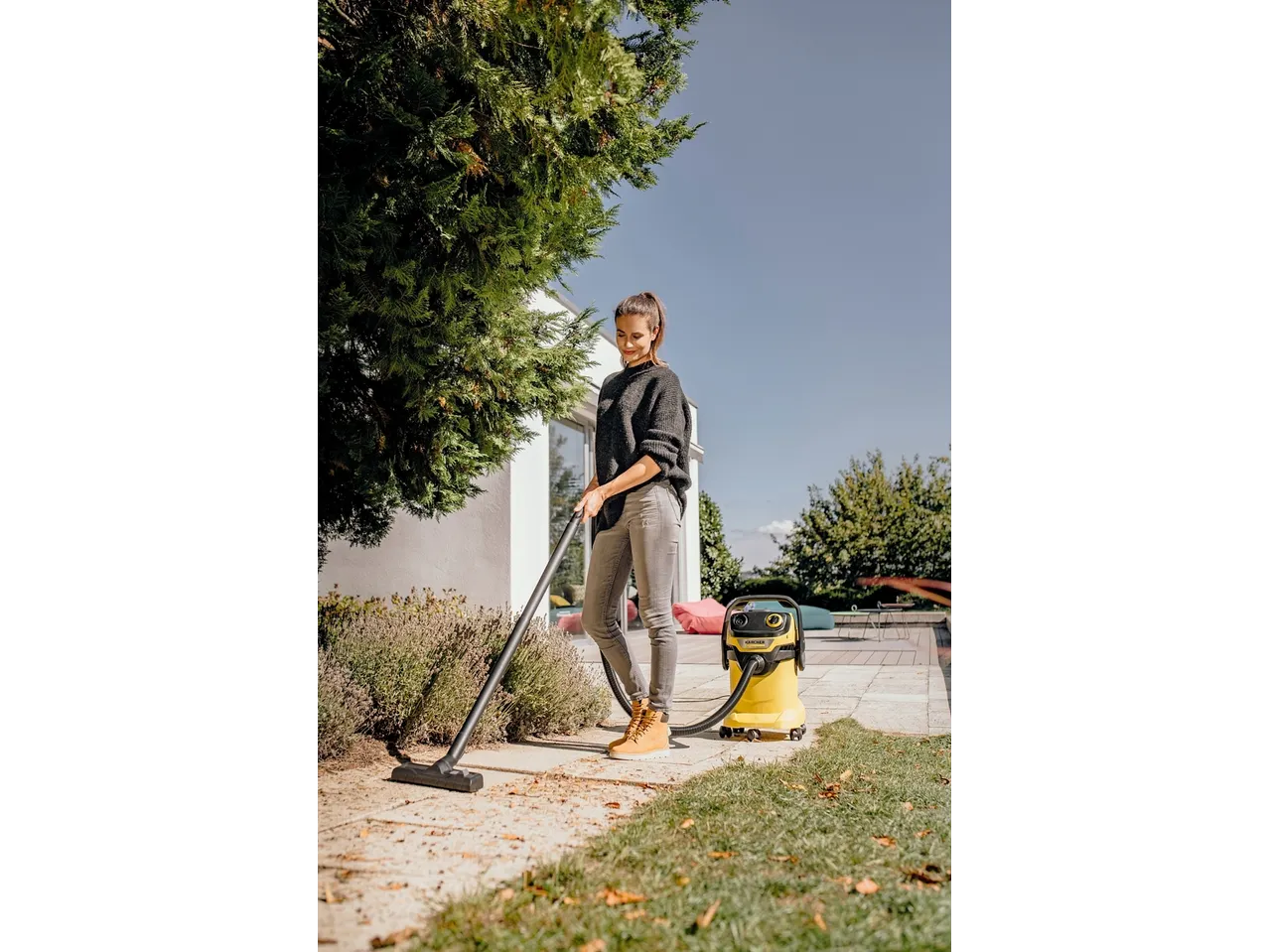 Žena koristi KÄRCHER usisavač za mokro i suho usisavanje za čišćenje vanjske terase.